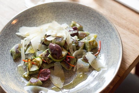 fresh nettle gnocchi with olives, zucchini & chilli