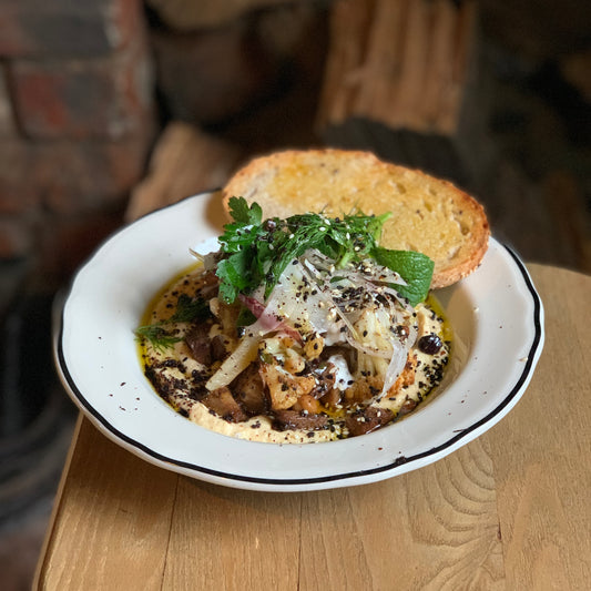 slow roasted lamb shoulder on hummus with pine nut & currant dressing